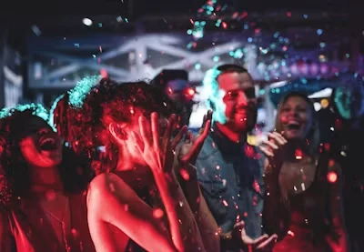 クラブの照明の下でダンスを楽しむ人々